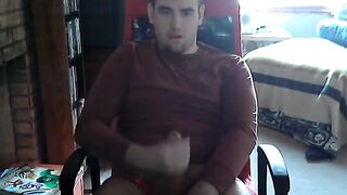 Young college guy strokes his cock while watching porn