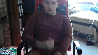 Young college guy strokes his cock while watching porn