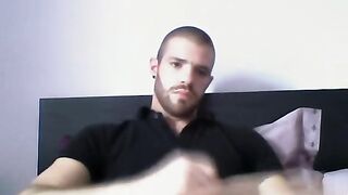 Handsome dude stroking his cock on his bed