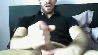 Handsome dude stroking his cock on his bed